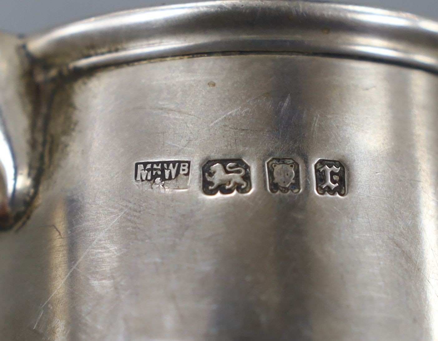 A late Victorian embossed silver christening mug, London, 1895, 10.5cm and a similar later silver mug, 10.5oz.